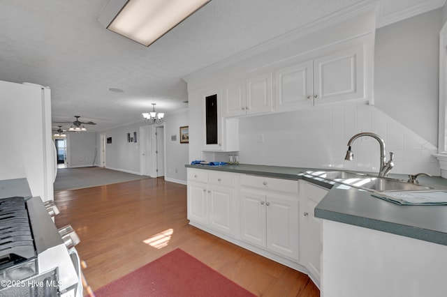 kitchen featuring ceiling fan with notable chandelier, white refrigerator, white cabinetry, and sink