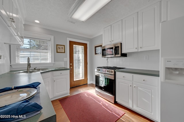 kitchen featuring a textured ceiling, sink, white cabinetry, and stainless steel appliances