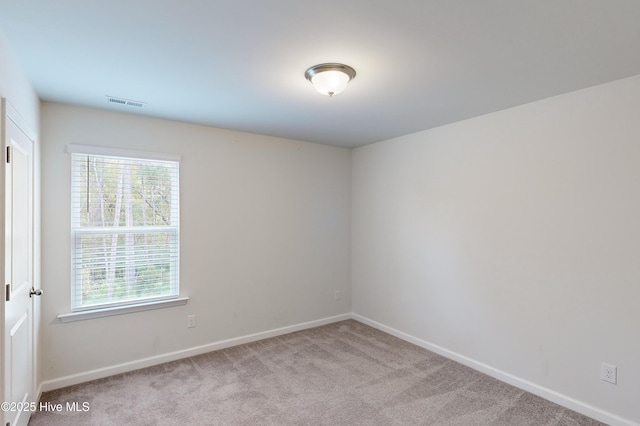 spare room featuring light colored carpet