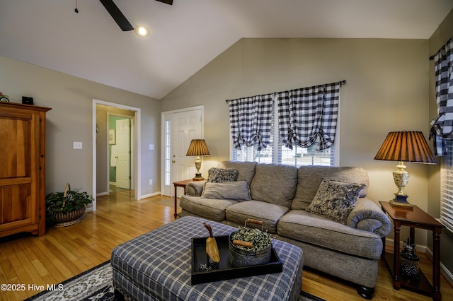 living room featuring ceiling fan, vaulted ceiling, and light wood-type flooring