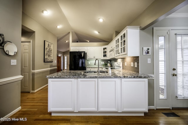 kitchen featuring white cabinetry, sink, dark stone counters, white appliances, and decorative backsplash