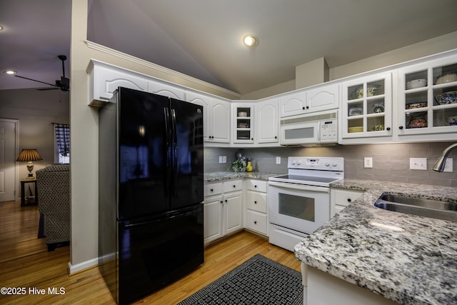 kitchen with white cabinetry, sink, light stone countertops, and white appliances