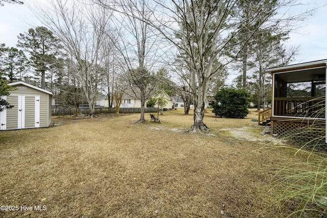 view of yard with a sunroom and a storage unit