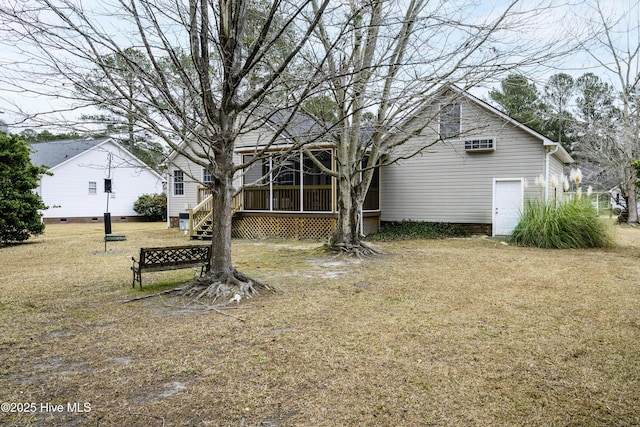 rear view of house with a lawn and a sunroom