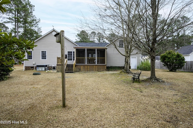 rear view of house with a yard, central AC unit, and a sunroom