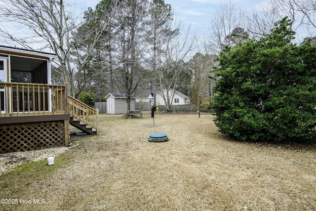 view of yard featuring a deck and a storage unit