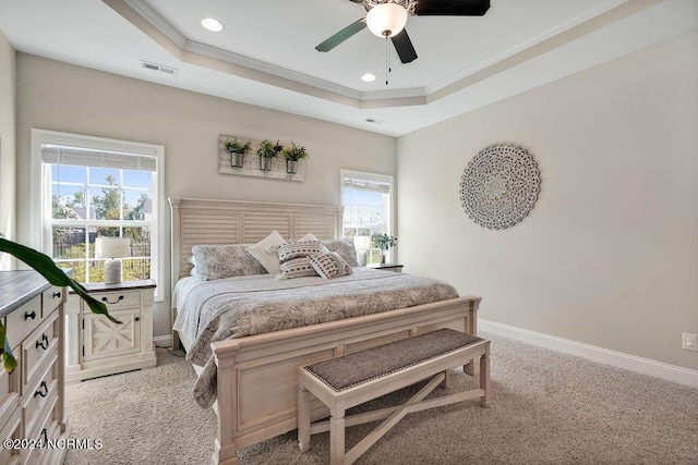 bedroom with a tray ceiling, ceiling fan, crown molding, and light colored carpet