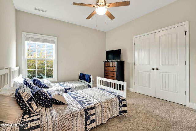 bedroom featuring ceiling fan, a closet, and light carpet