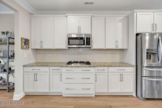 kitchen featuring tasteful backsplash, white cabinetry, light stone countertops, and appliances with stainless steel finishes