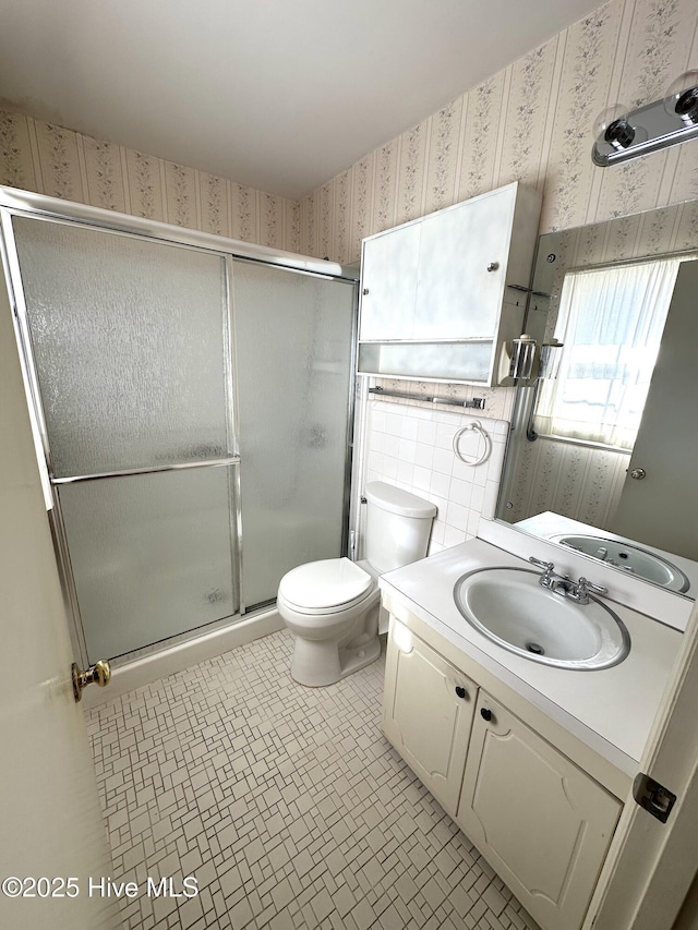 bathroom featuring tile patterned floors, toilet, a shower with door, and vanity