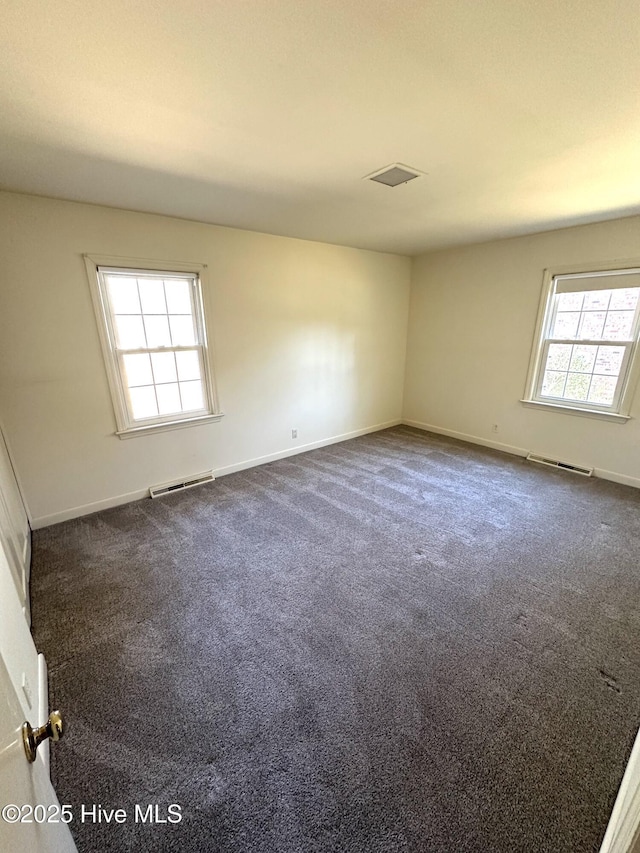 spare room featuring dark carpet