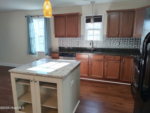 kitchen with light stone countertops, stainless steel dishwasher, sink, pendant lighting, and dark hardwood / wood-style floors