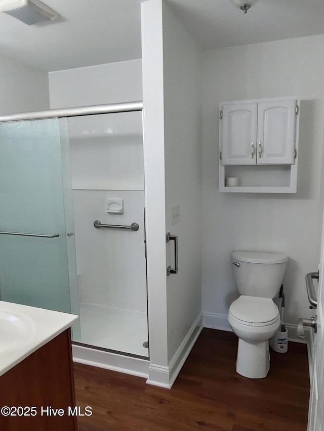 bathroom featuring vanity, hardwood / wood-style flooring, toilet, and an enclosed shower