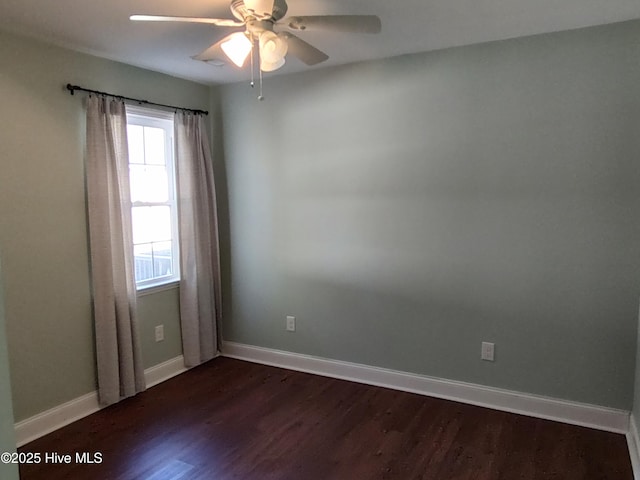 empty room with ceiling fan and dark hardwood / wood-style flooring