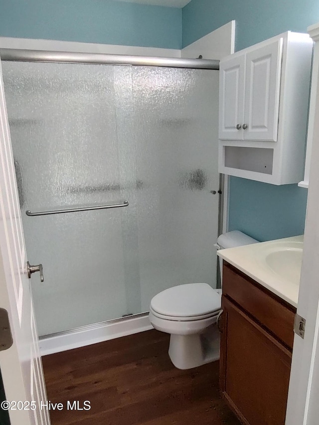 bathroom featuring hardwood / wood-style floors, vanity, toilet, and an enclosed shower