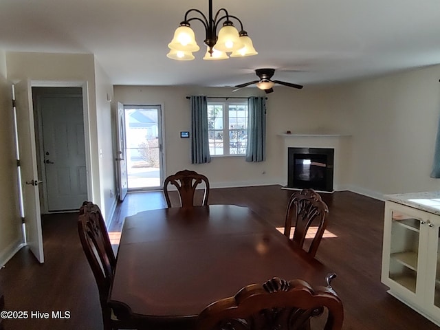 dining space with dark hardwood / wood-style floors and ceiling fan with notable chandelier