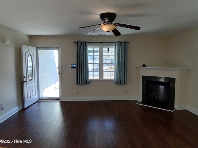 unfurnished living room featuring ceiling fan and dark wood-type flooring