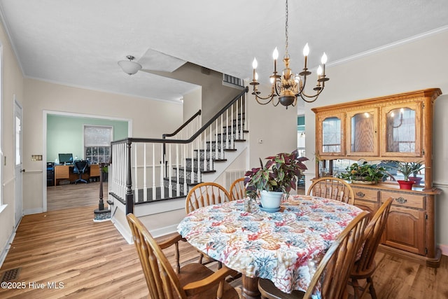 dining space featuring ornamental molding and light hardwood / wood-style floors