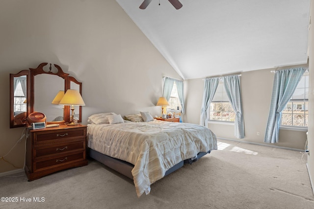 carpeted bedroom with ceiling fan and high vaulted ceiling