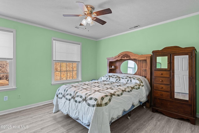 bedroom featuring crown molding, ceiling fan, light hardwood / wood-style flooring, and a textured ceiling