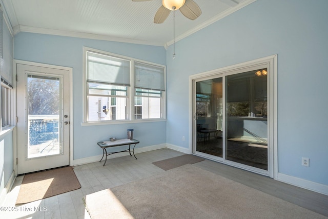 doorway featuring crown molding, a healthy amount of sunlight, ceiling fan, and light wood-type flooring