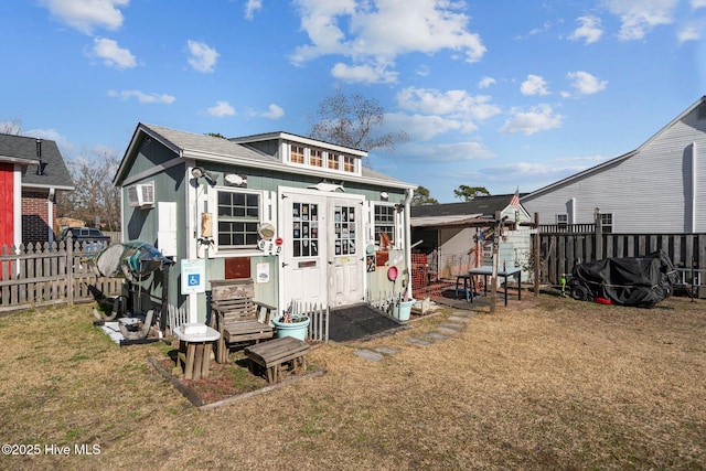 rear view of house featuring a storage shed and a lawn