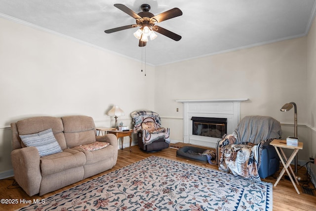 living room featuring crown molding, ceiling fan, and light hardwood / wood-style floors