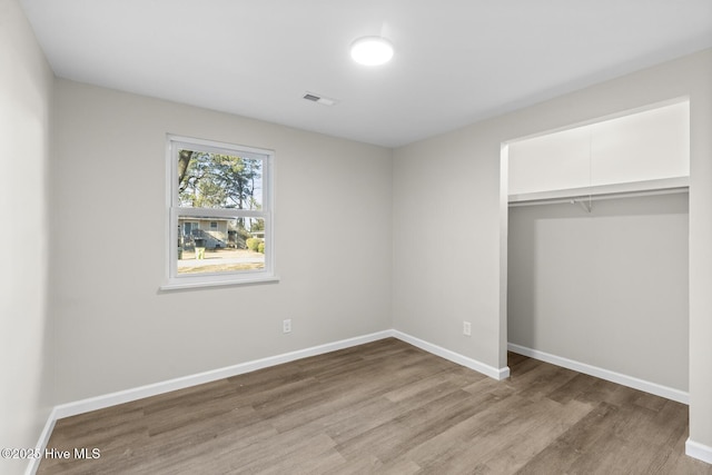 unfurnished bedroom featuring light hardwood / wood-style flooring and a closet