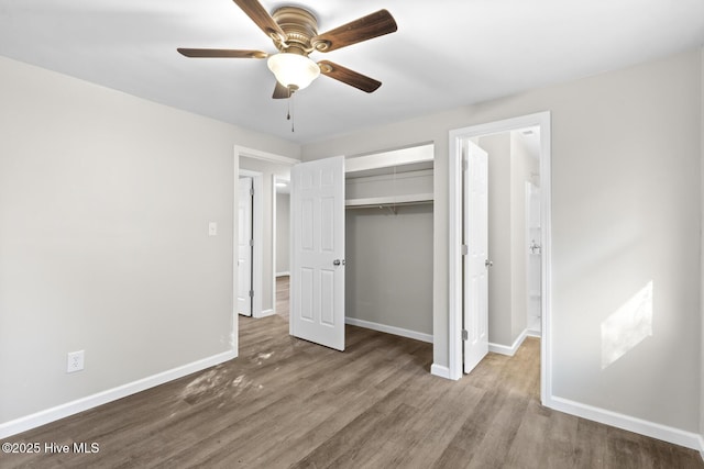 unfurnished bedroom with ceiling fan, a closet, and hardwood / wood-style flooring