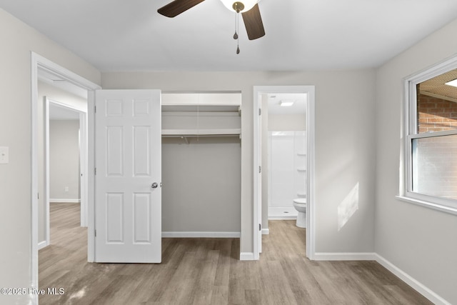 unfurnished bedroom featuring ceiling fan, a closet, ensuite bathroom, and light wood-type flooring