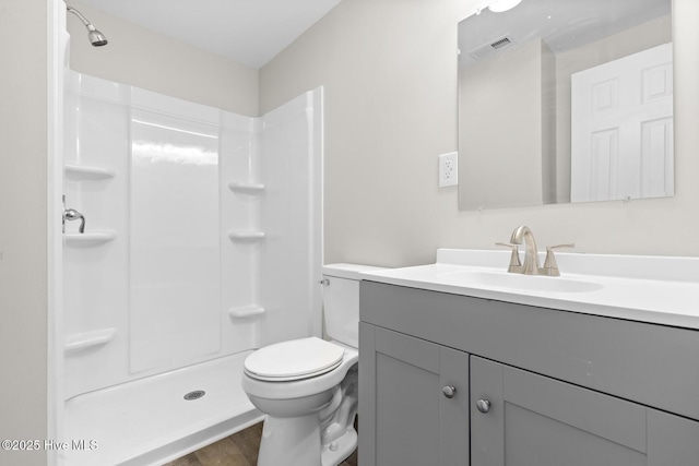 bathroom featuring hardwood / wood-style flooring, vanity, toilet, and walk in shower