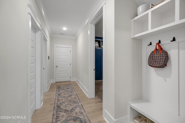 mudroom with light hardwood / wood-style floors and crown molding