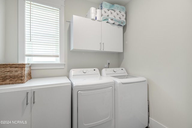 washroom featuring cabinets and washer and dryer