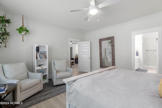 bedroom with ceiling fan, light hardwood / wood-style floors, and ensuite bath