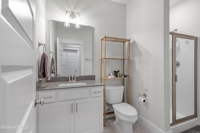 bathroom with vanity, toilet, and a shower with door