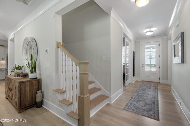 entrance foyer with light hardwood / wood-style floors and ornamental molding