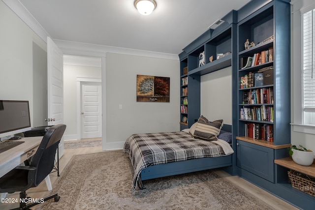 bedroom featuring hardwood / wood-style flooring and crown molding