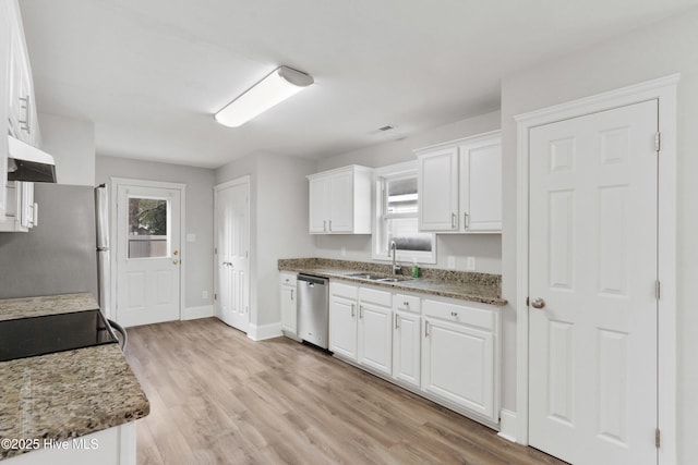 kitchen featuring dark stone counters, white cabinetry, sink, and stainless steel appliances