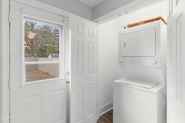 clothes washing area featuring stacked washer and dryer and dark hardwood / wood-style floors