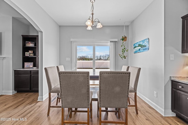 dining space featuring light hardwood / wood-style flooring and a notable chandelier