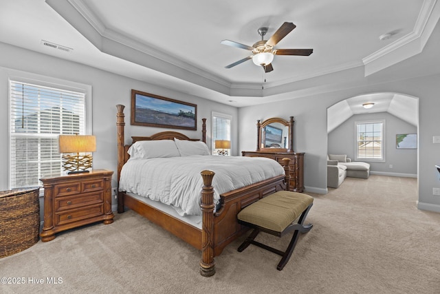 carpeted bedroom featuring a tray ceiling, ceiling fan, and ornamental molding