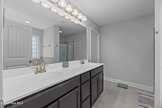 bathroom featuring tile patterned floors, vanity, and a shower with shower door