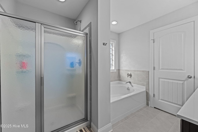 bathroom featuring tile patterned flooring, shower with separate bathtub, and vanity