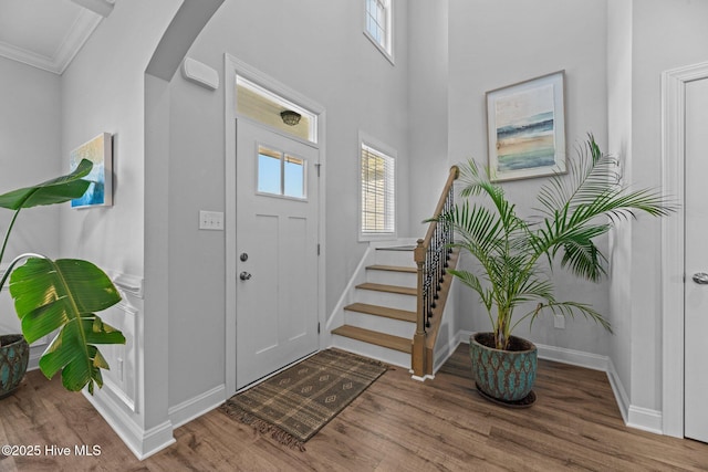 foyer entrance with hardwood / wood-style flooring and ornamental molding