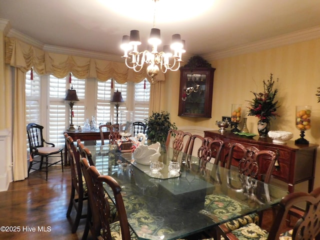 dining area with ornamental molding, dark wood-type flooring, and a chandelier