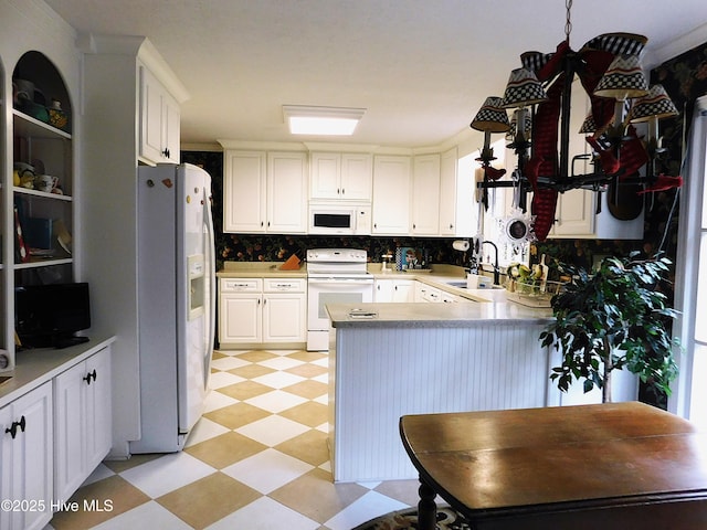 kitchen with kitchen peninsula, ornamental molding, white appliances, sink, and white cabinets