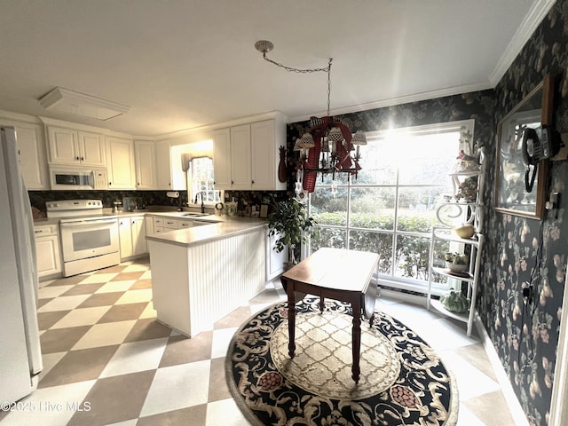 kitchen with pendant lighting, white appliances, sink, kitchen peninsula, and white cabinetry