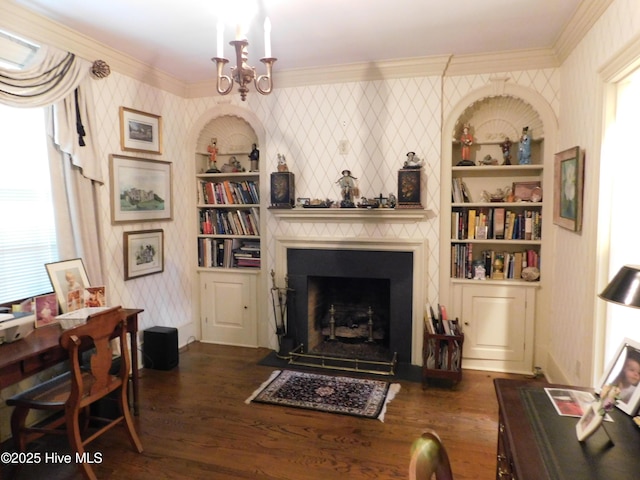 living area featuring a chandelier, ornamental molding, built in features, and dark wood-type flooring