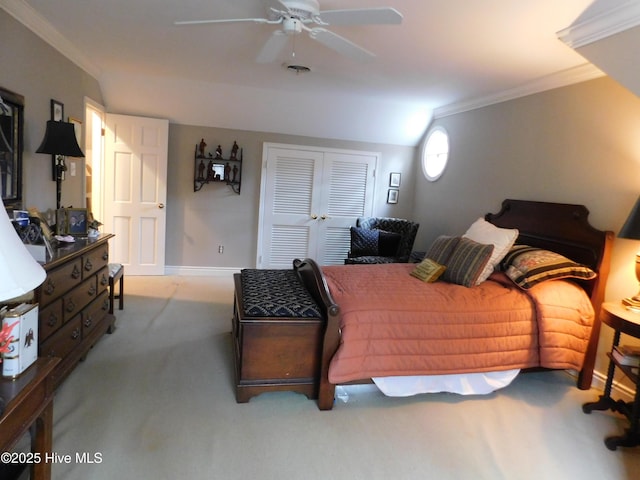 carpeted bedroom featuring ceiling fan, a closet, and crown molding