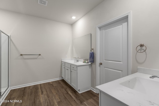 bathroom featuring wood-type flooring, vanity, and a shower with door